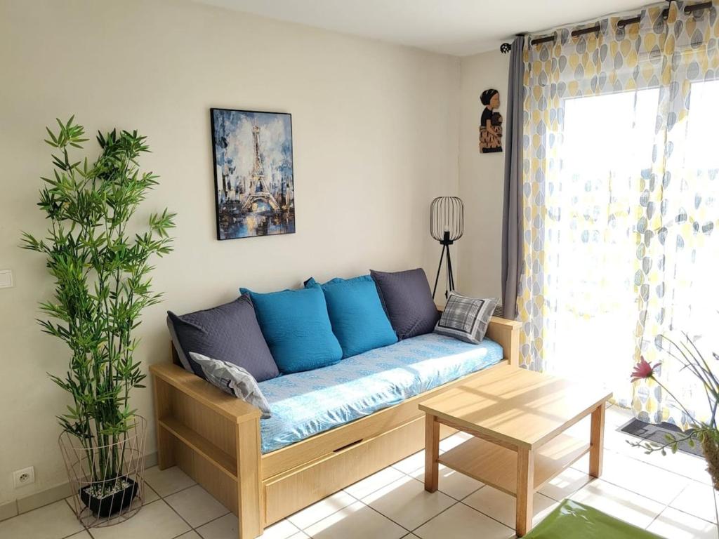 a living room with a blue couch in a room at Havre de paix à Azay-le-Rideau - piscine chauffée in Azay-le-Rideau