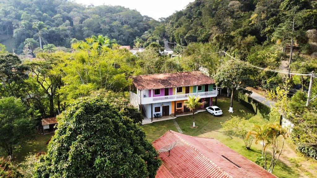a house with a car parked in front of it at Pousada Maria Laura in Guararema