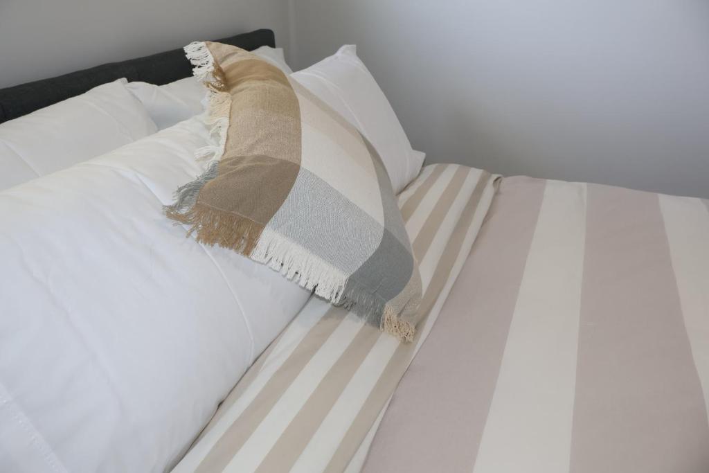 a white bed with a pillow on it at Proline Serviced Apartments 