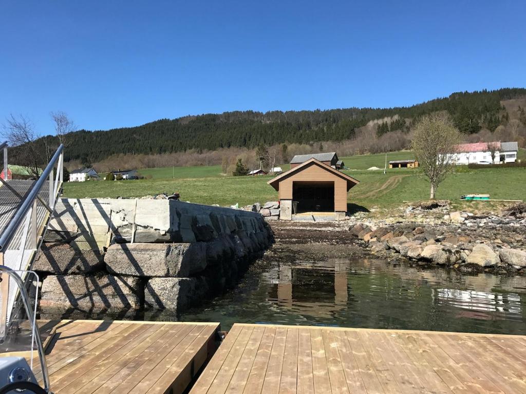 een uitzicht op een rivier met een houten dock bij Strand farm, sea view and boat rental in Averoy