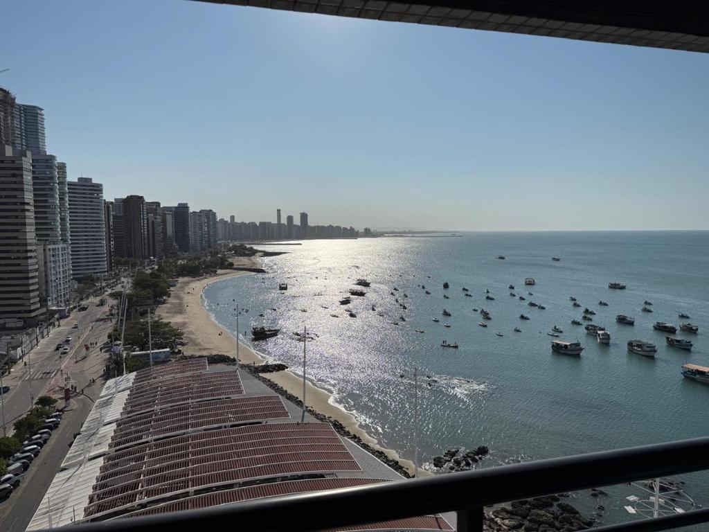 una vista di una spiaggia con barche in acqua di Flat - Iate Plaza Hotel a Fortaleza