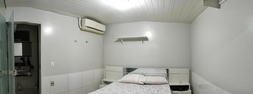 una camera con un letto con cuscini rosa di Quarto em casa de família a Belém