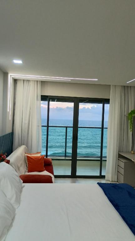 Un dormitorio con una cama y vista al mar. en Studio Luxuoso vista Mar, en Salvador
