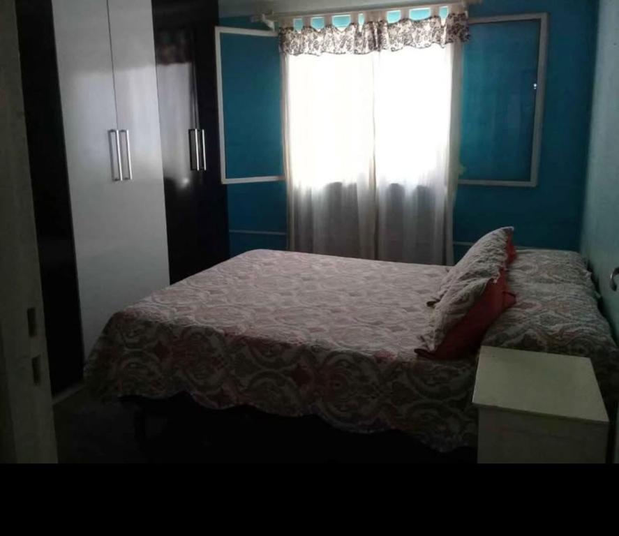 un dormitorio con una cama y una ventana en Comparto mi casita, en Salta