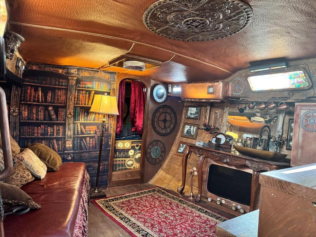 a living room in an rv with a couch and a tv at The Victorian Voyager in Kemah