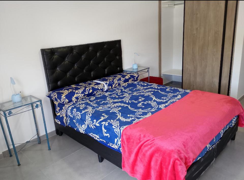 ein Schlafzimmer mit einem Bett mit einer blau-weißen Bettdecke in der Unterkunft Centro Carlos Paz Cibeles in Villa Carlos Paz