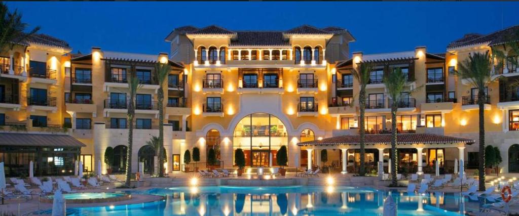 ein großes Gebäude mit einem Pool davor in der Unterkunft Villa Marrajo La Torre Golf Resort in Torre-Pacheco