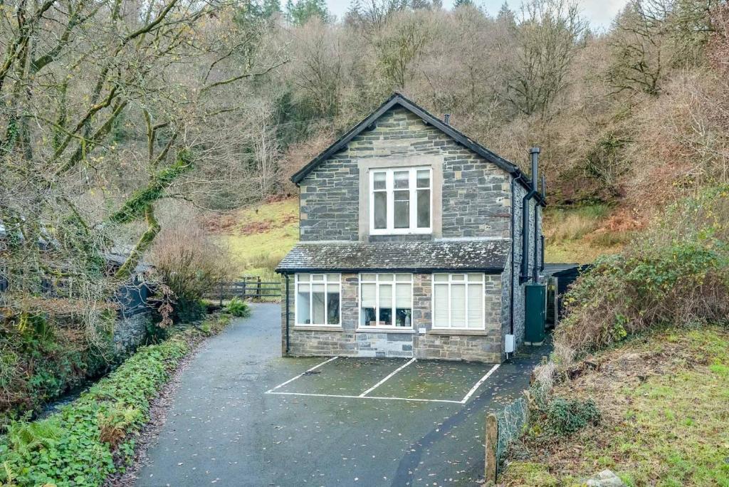 a small house sitting in the middle of a road at Pwerdy in Betws-y-coed