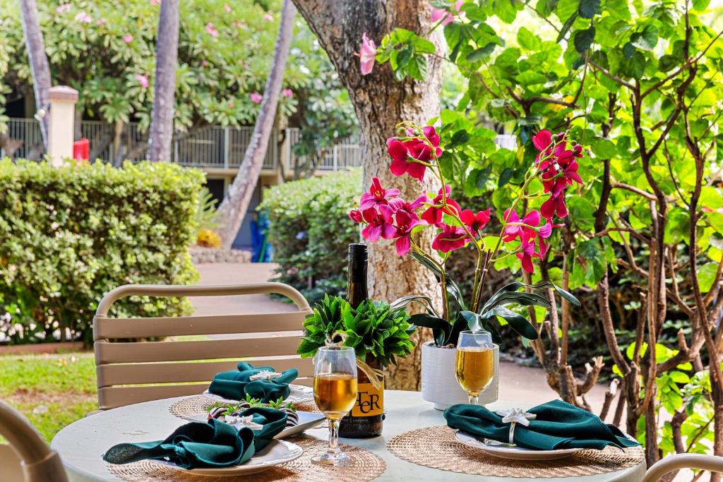 a table with glasses of wine and flowers on it at Napili Shores F145 in Kapalua