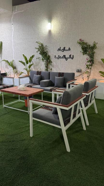 a living room with couches and a table and chairs at شاليه ليالي الفندقيه in Taif