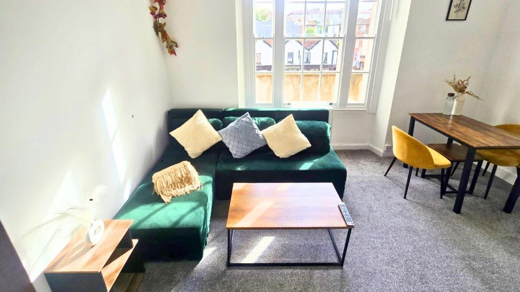 a living room with a green couch and a table at City Chic Stay in Bristol in Bristol