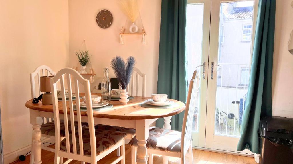 a dining room with a table and chairs and a window at Urban Oasis Stylish Boho Flat in Bristol in Bristol