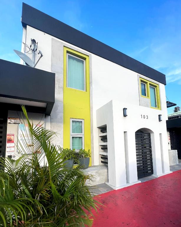 a white and yellow building with a red driveway at Tapia Haus 103 - San Juan, Beach Vibes Walking Distance in San Juan