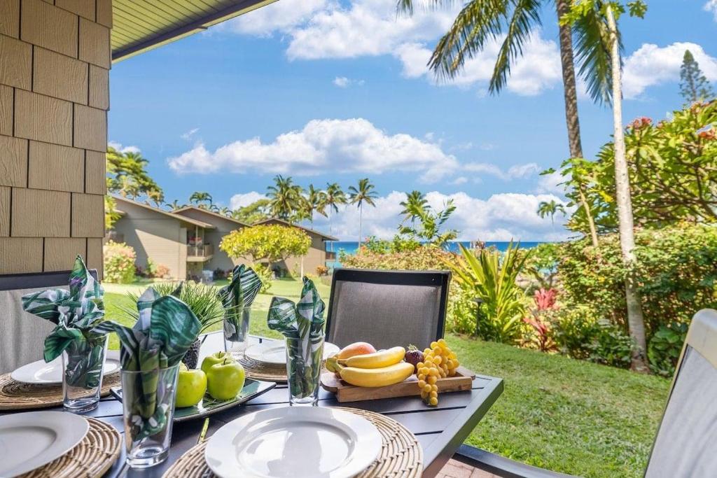 a table with a plate of fruit on top of it at Polynesian Shores 111 · PS 111 Updated Condo w Ocean Views Pool in Kahana