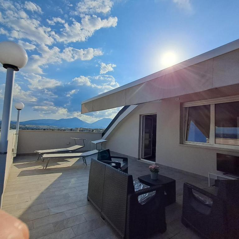 ein Balkon eines Hauses mit einer Couch und Stühlen in der Unterkunft Terrazza D'Abruzzo in Nereto