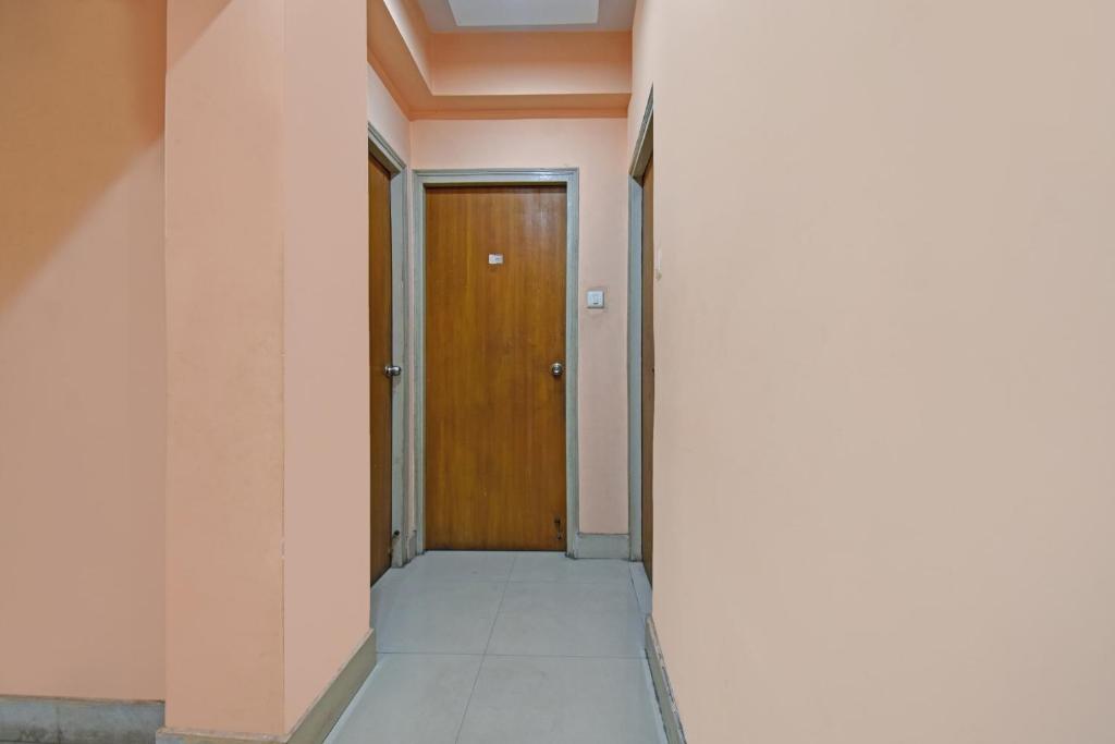 a hallway with a wooden door in a building at Hotel O Sai City inn in Jādabpur