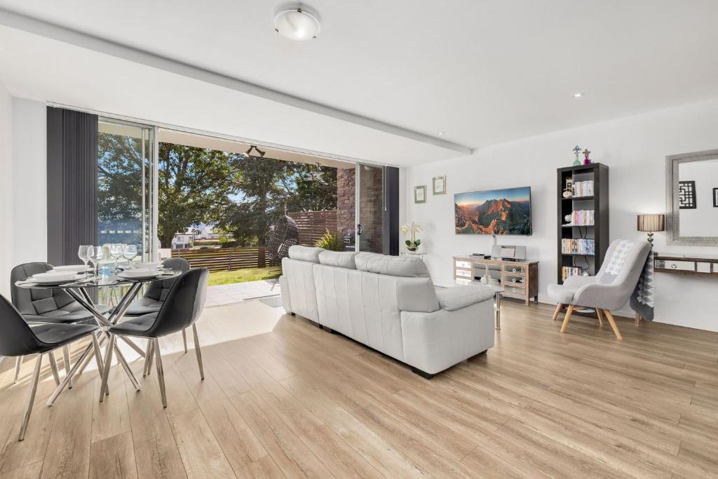 a living room with a couch and a table and chairs at Edge One - Dog Friendly Jindabyne Holiday Apartment in Jindabyne