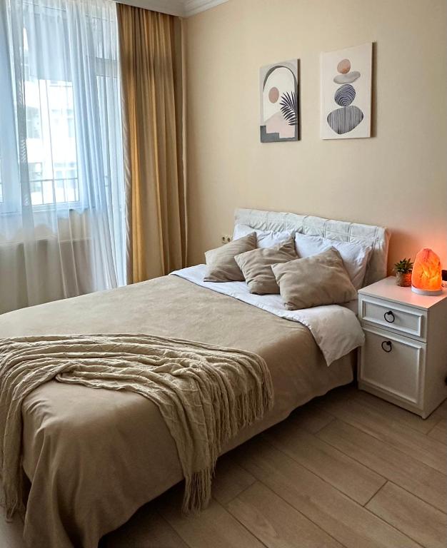 a bedroom with a large bed and a window at Cozy studio with a balcony and sea view in Batumi