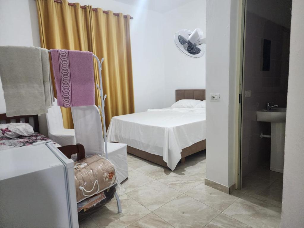 a bedroom with a bed and a chair and a sink at Bujtina Ismet Gjeli 