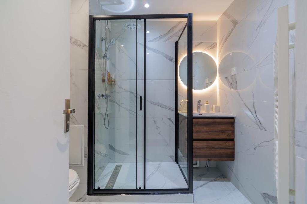 a shower with a glass door in a bathroom at Sous les Étoiles! in Saint-Ouen