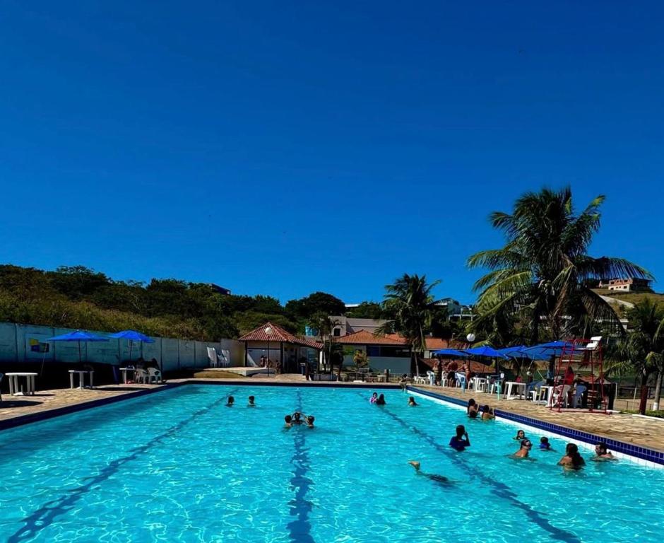 a group of people swimming in a swimming pool at Marina Clube in São Pedro da Aldeia
