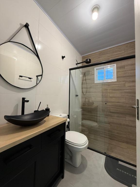 a bathroom with a sink and a toilet and a shower at Casa Nova com 3 quartos in São Gabriel