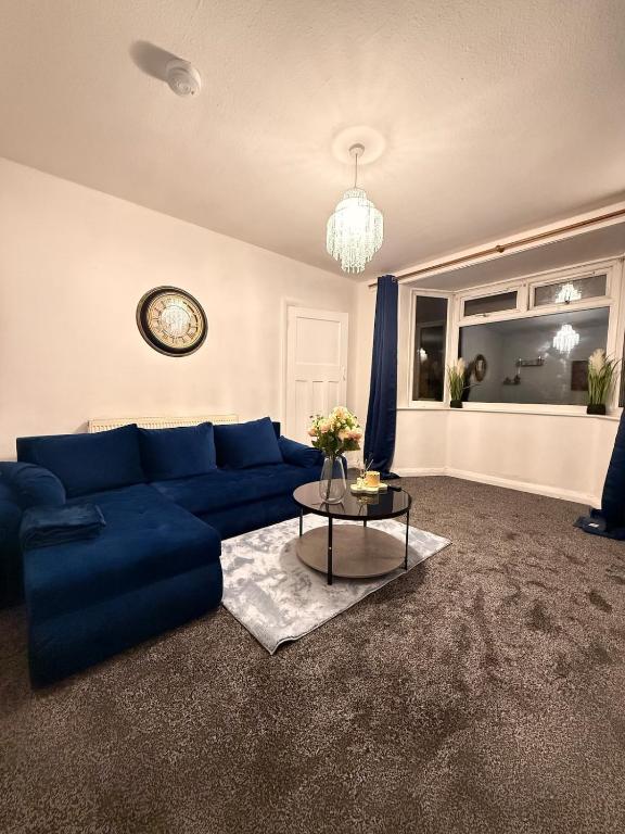 a living room with a blue couch and a table at The Royal Hue 4bed house close to city centre in CBG