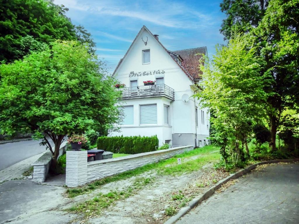 een wit huis met een boom ervoor bij Hubertus I in Bad Pyrmont