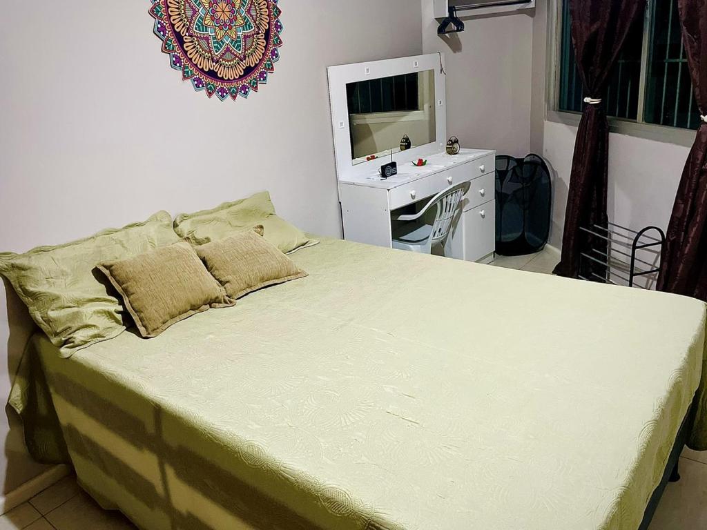 a bedroom with a bed with a desk and a television at Quartos Privativos Com Cama de Casal in Vitória