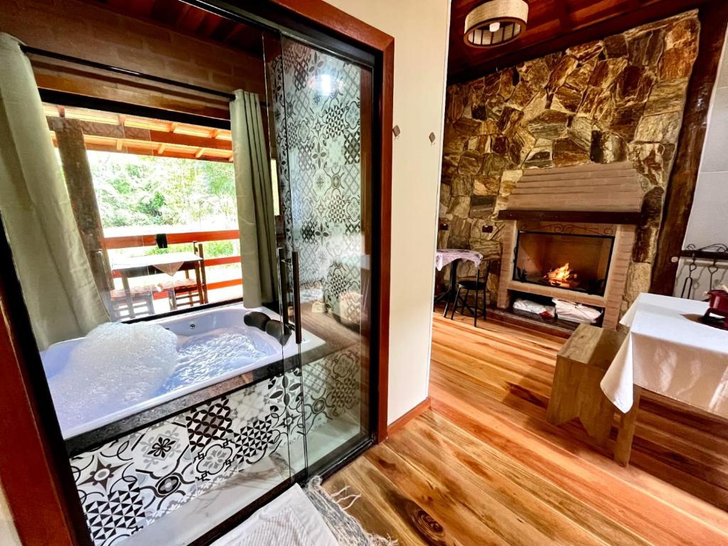 a bathroom with a tub in a room with a fireplace at Chalés Aguas Serenas in Santo Antônio do Pinhal