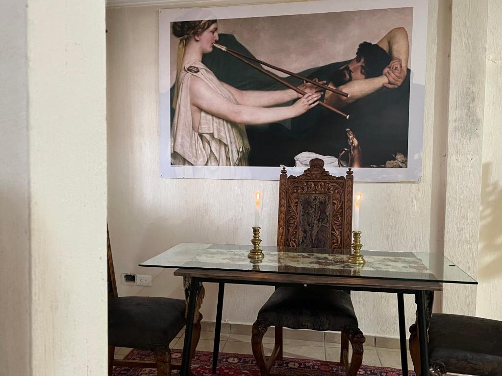 a table with a candle and a painting on the wall at Birdhouse in Guanajuato