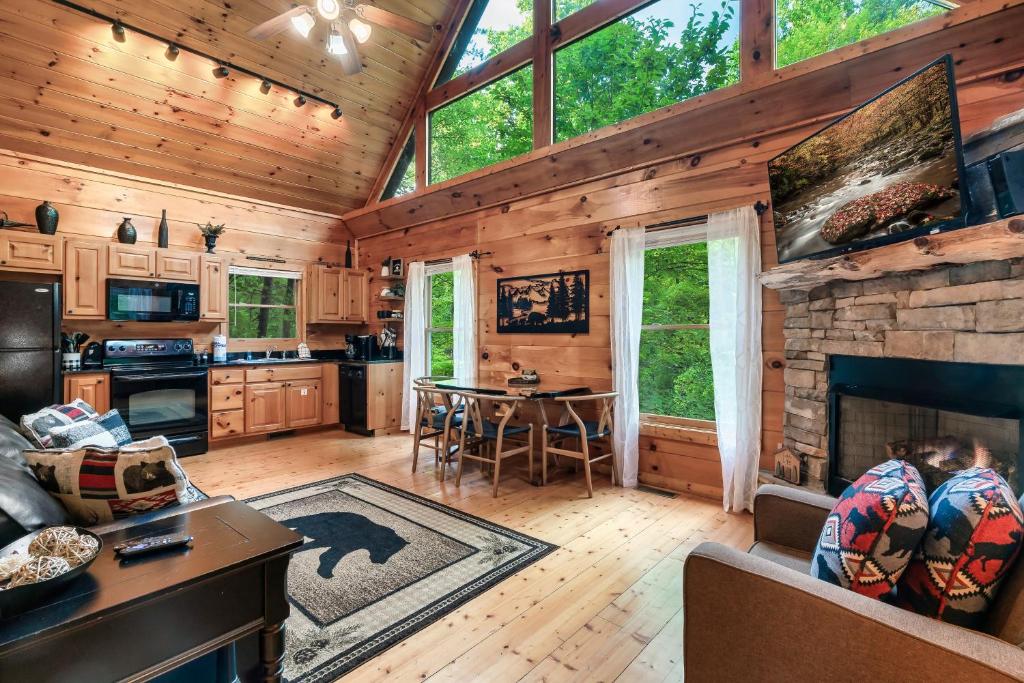 a kitchen and living room with a fireplace in a log cabin at Ever & After Cabin in Pigeon Forge