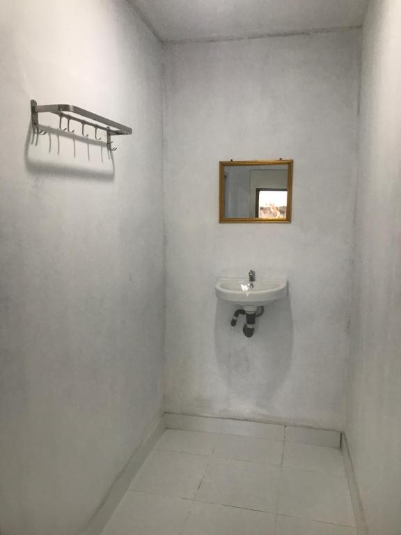 a white bathroom with a sink and a mirror at Gina's Reading Homestay 