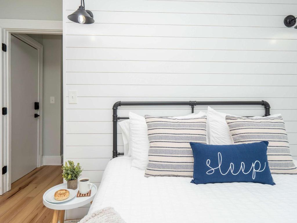 a bedroom with a bed with white and blue pillows at Jennifer's Modern & Comfy Broadway Retreat in Providence