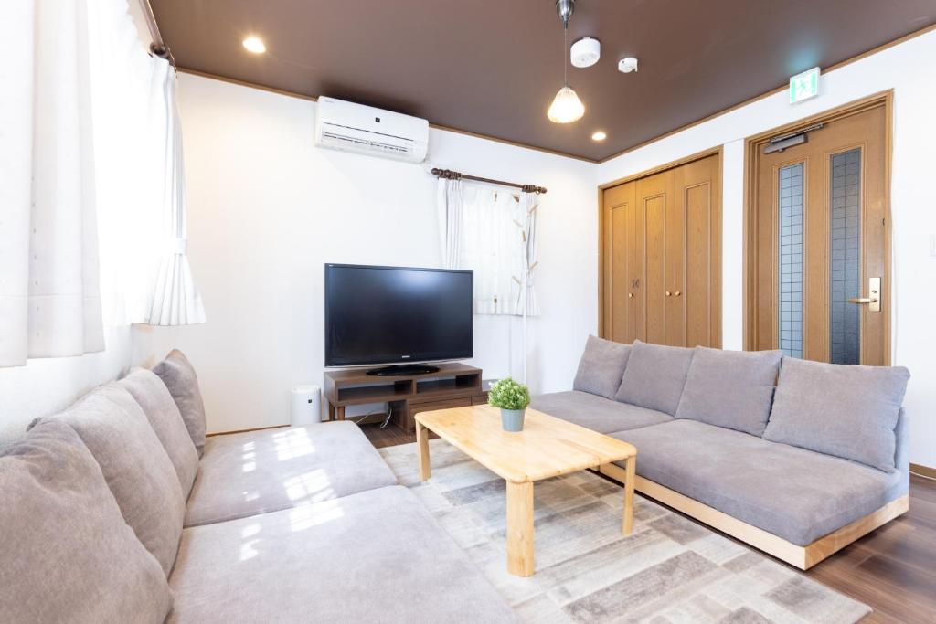 a living room with a couch and a tv at Y's INN Tsutusji 014T in Tokyo