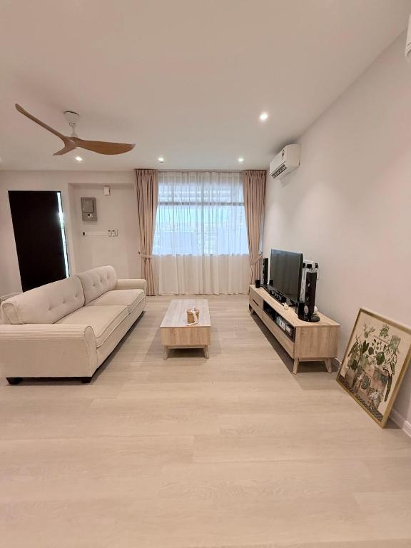 a living room with a couch and a tv at Taman Bagan Homestay in Butterworth