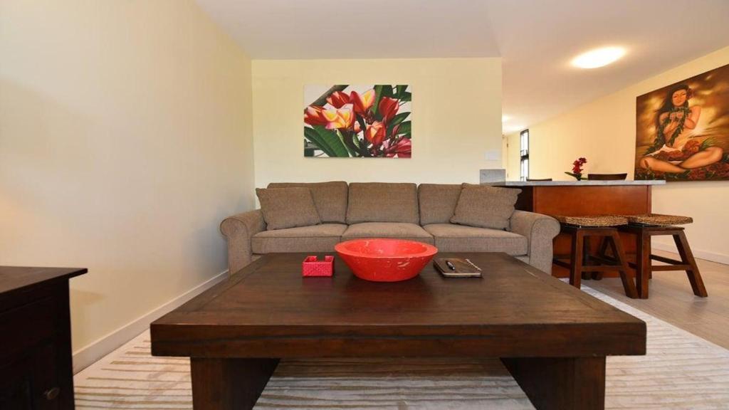 a living room with a couch and a table at Kaleialoha 401 · KA 401 Spacious Studio w Mountain View Pool AC in Kahana