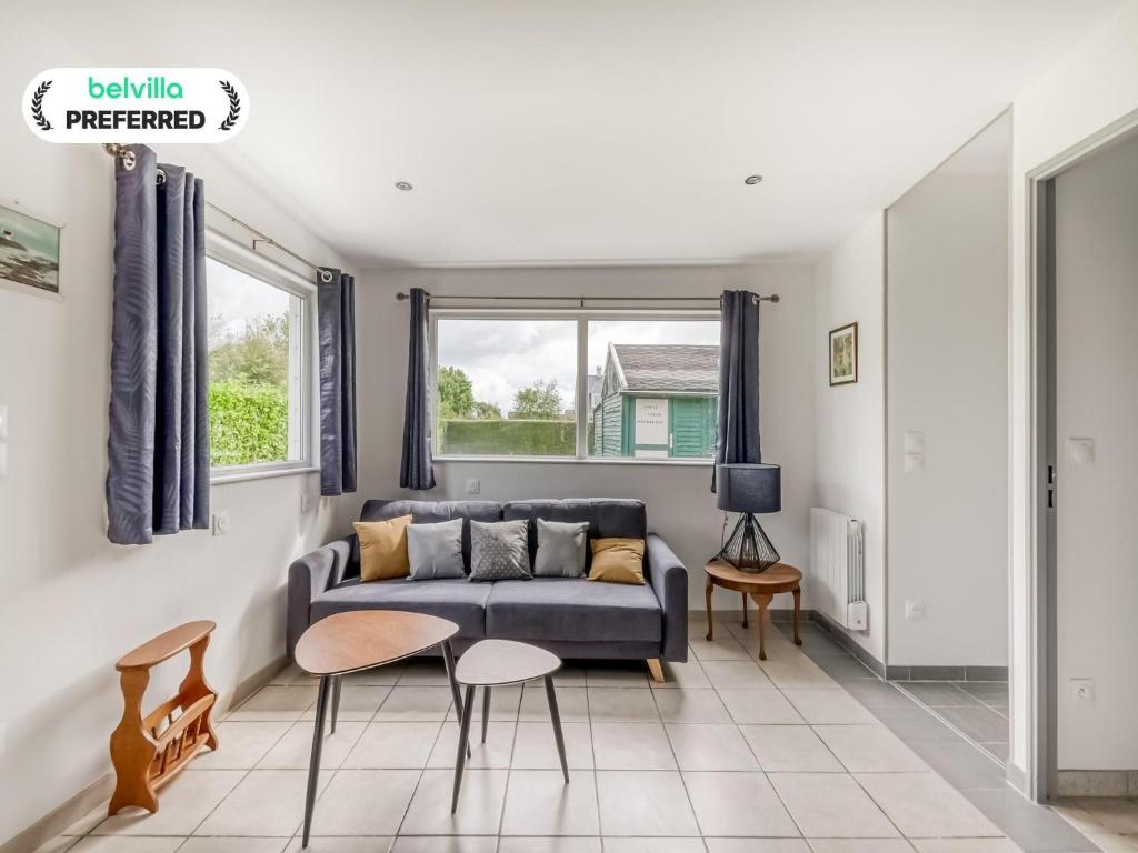 a living room with a blue couch and chairs at Bronte s Coastal Retreat in Tracy-sur-Mer