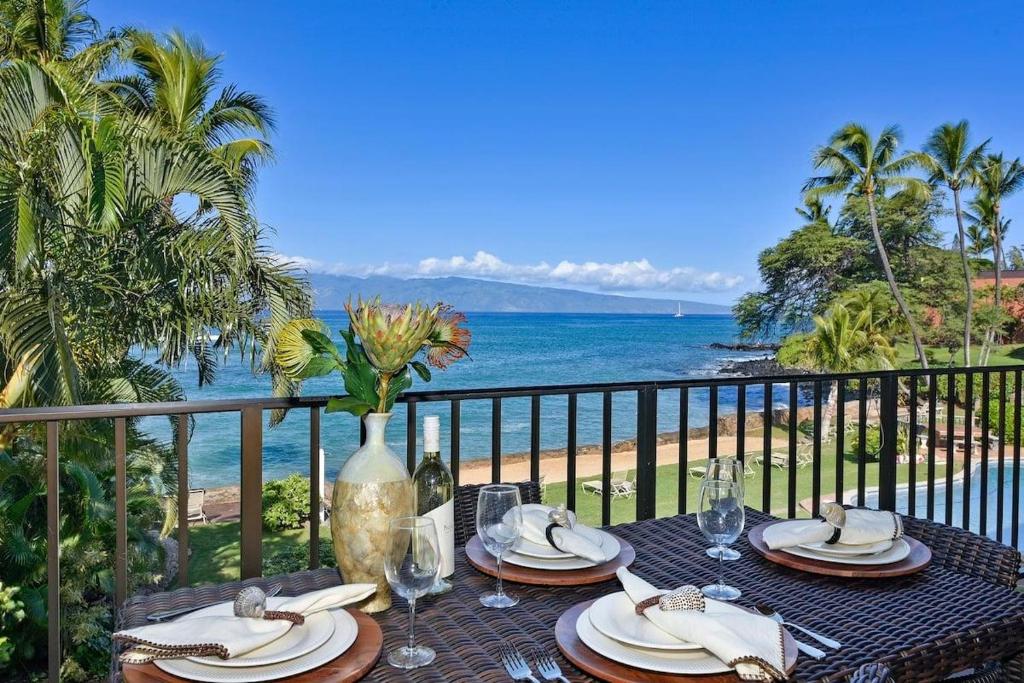 a table on a balcony with a view of the beach at Hoyochi Nikko 201 · HN 201 Relaxing Getaway OceanFront 2BD wPool in Kahana