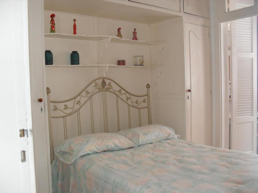 ein Schlafzimmer mit einem Bett mit Regalen an der Wand in der Unterkunft Brazil Cozy and Comfortable in Rio de Janeiro
