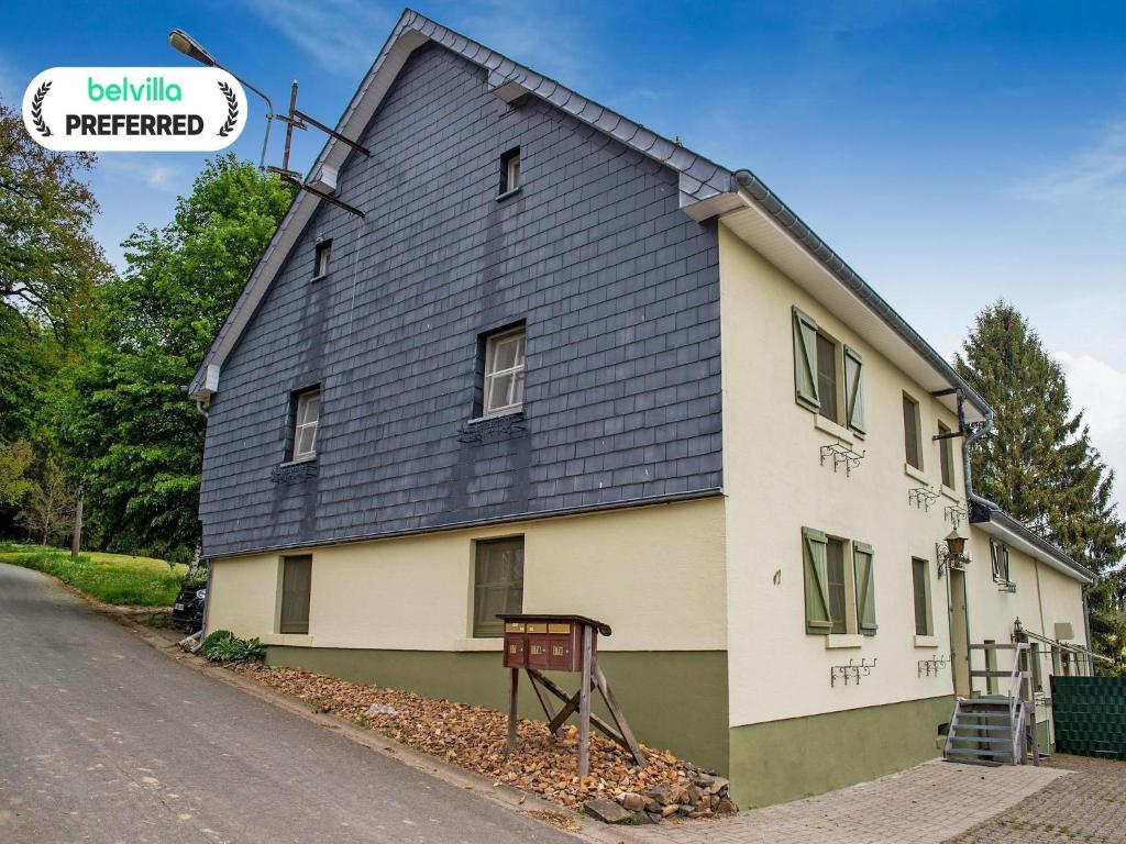 a house with a black roof on a street at Holiday Home near Ravel Cycling paths in Heuem