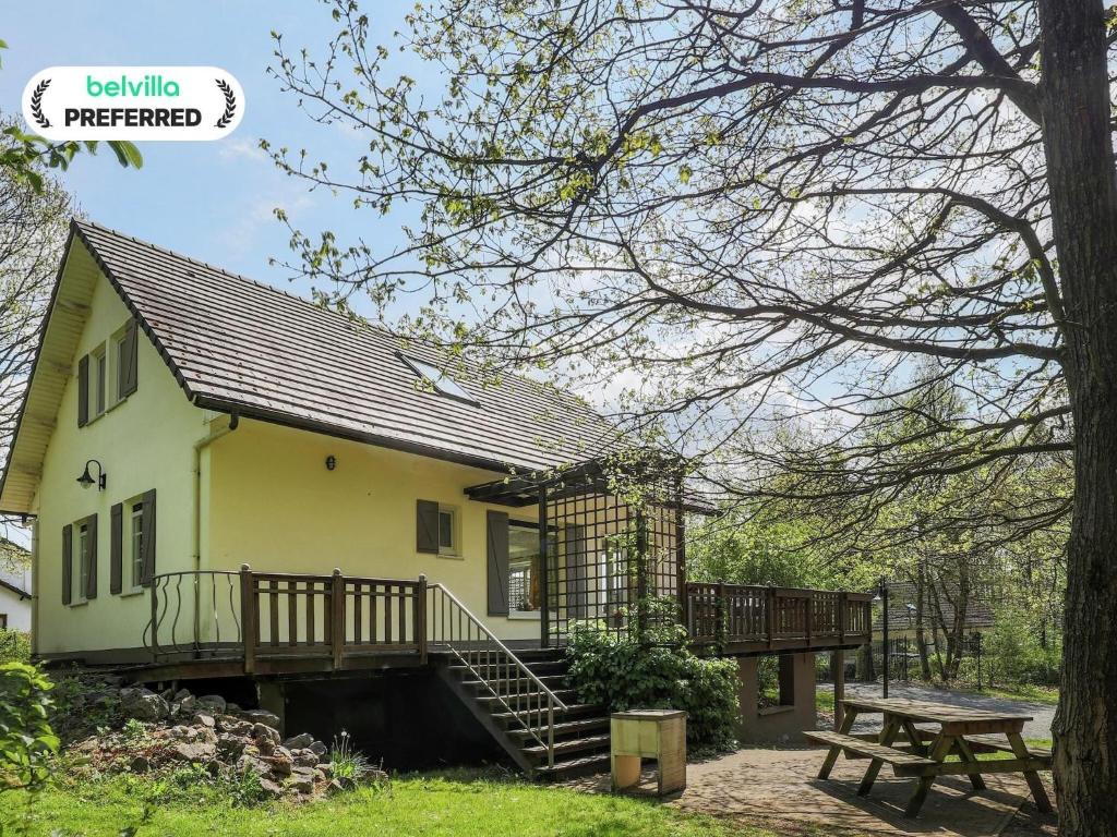a house with a wooden staircase and a picnic table at Rendeux Villa with Garden in Consy
