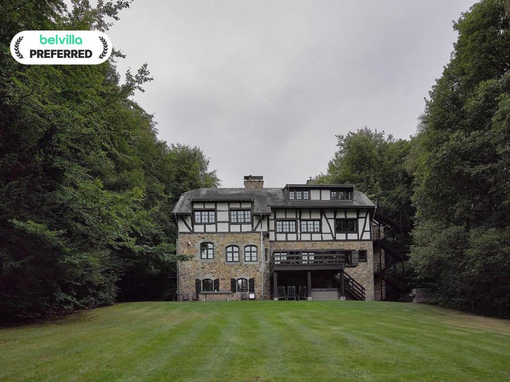 una gran casa de piedra con un gran patio de césped en Spacious Villa in Liège, en Spa