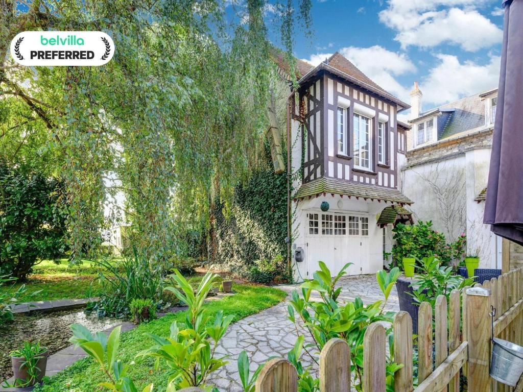 a house with a fence and a garden at Harbor View Hideaway in Isigny-sur-Mer
