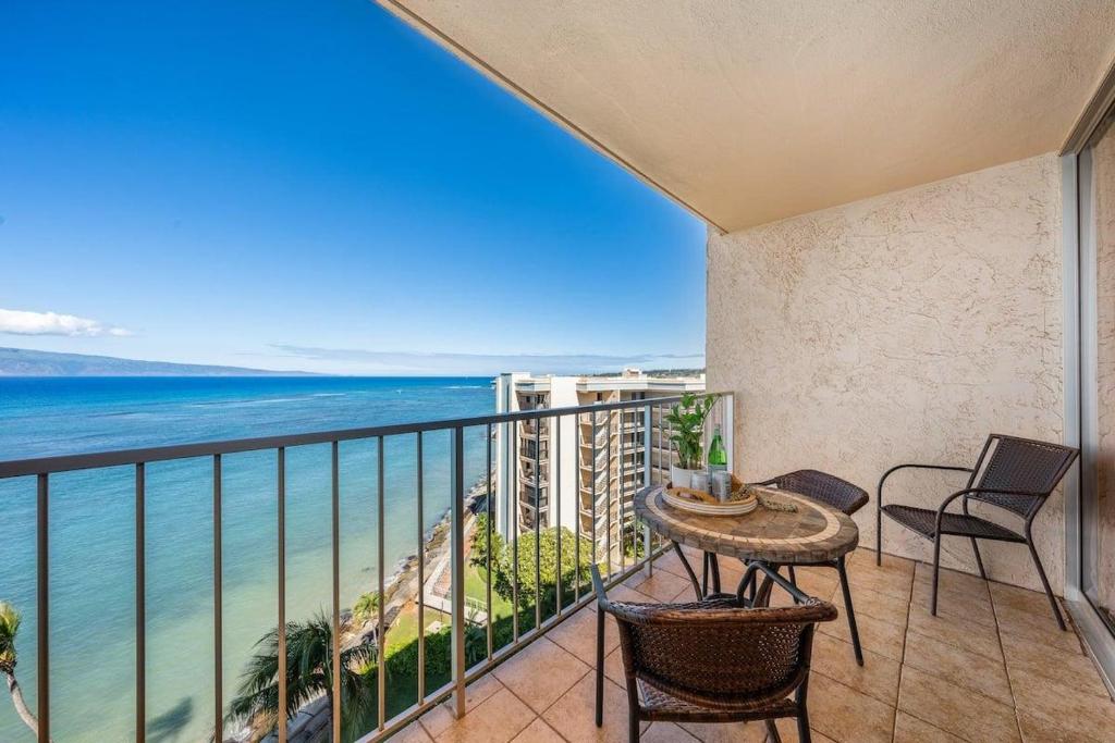a balcony with a table and chairs and the ocean at Royal Kahana 909 · RK 909 OceanFront Condo w Beautiful Ocean Vie in Kahana