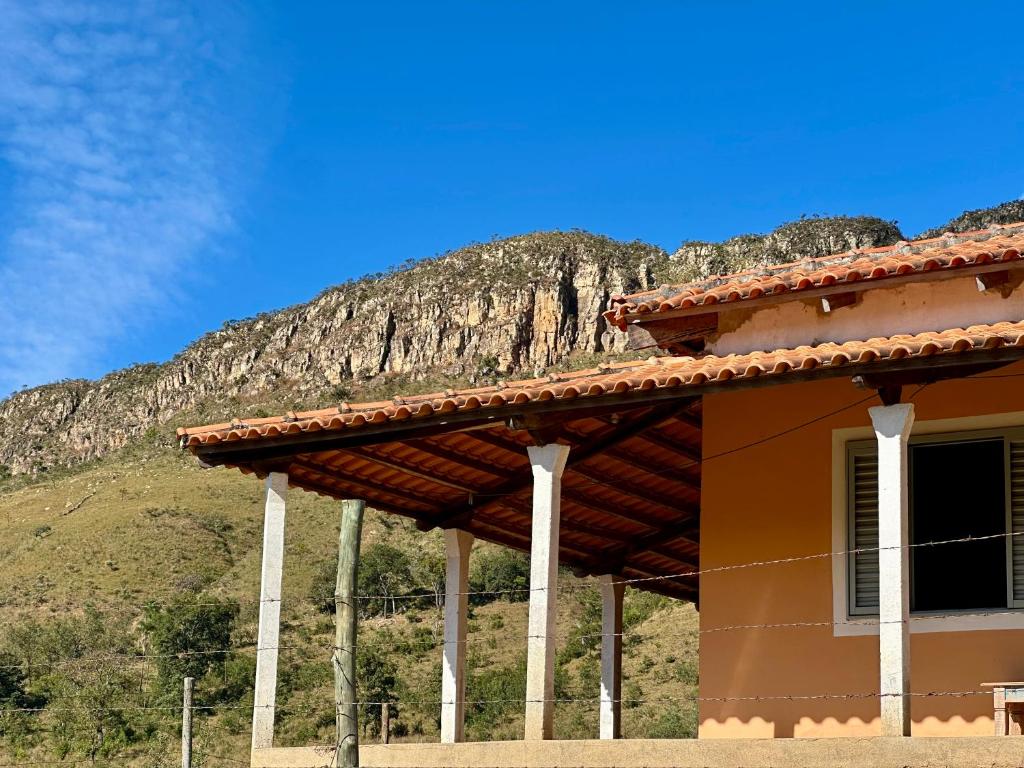 a building with a mountain in the background at Casa no Vale da Babilônia Serra da Canastra in Delfinópolis