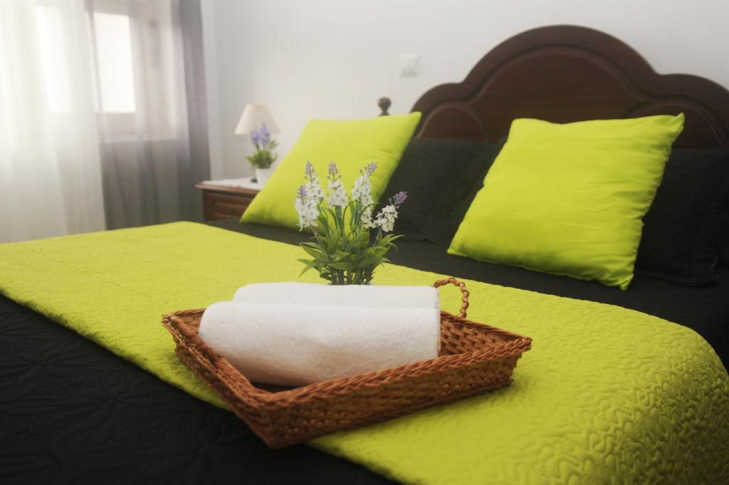 a wicker basket with a towel on a bed at Apartamento Couto in Ponta Delgada