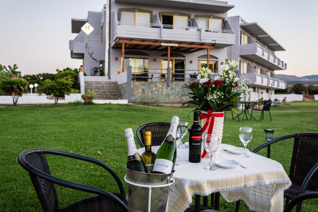 - une table avec des bouteilles de vin et des verres à vin dans l'établissement Nereides Hotel, à Kolymbari