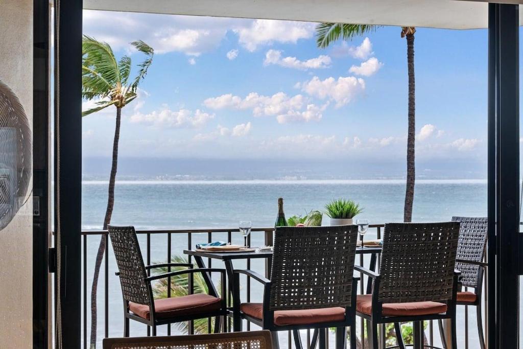 a table and chairs on a balcony with the ocean at Milowai 302 · MIL 302 Oceanfront 2BD w Ocean Views Whale Watch in Wailuku
