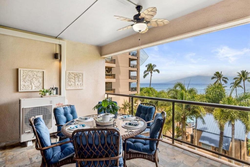 a dining room with a table and chairs and a balcony at Sands of Kahana 134 · SK 134 Beautifully Updated Spacious 2BD Oc in Kahana